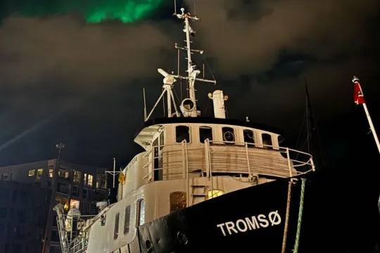 Bilde av båten med nordlyset i bakgrunnen.