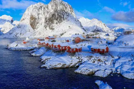 Rorbuer og Snødekte fjell ved kysten