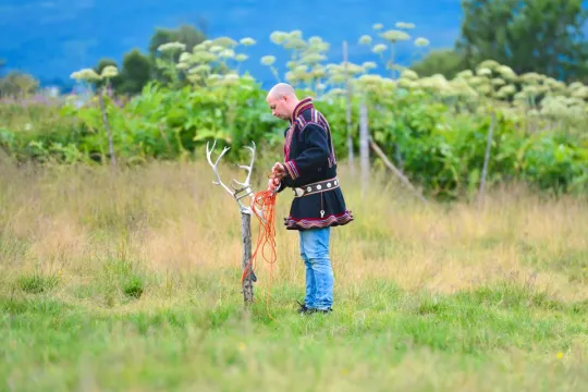 A Sámi person preparing for lasso throwing