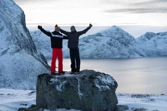 Gjester tar bilde med fjell og fjord i bakgrunnen