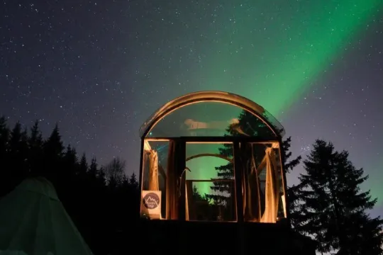 glasshytta med nordlys over