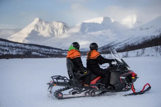 Guests look out over the mesmerising mountains from their snow scooter
