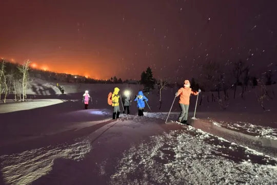 Guests out on snowshoeing trip at night