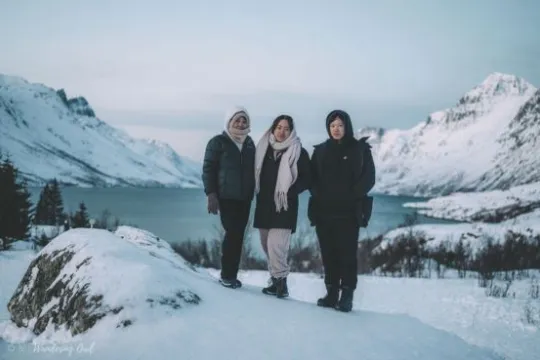 Guests in snowy landcape with a fjord in the background