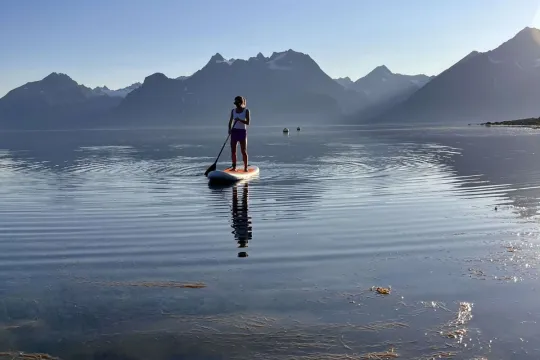 Gjest står på et SUP-brett