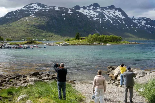 Gjester tar bilder av fjell og kystlandskap