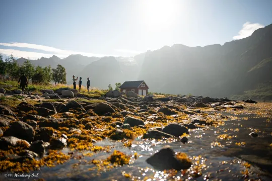 Noen personer ved en bygning ved fjæra