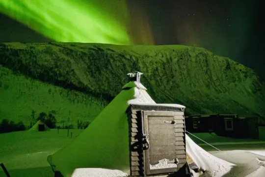 Lavvoen under nordlyset i et vinterlandskap