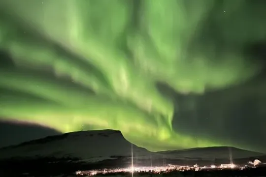 Nordlys dekker himmelen over et fjell