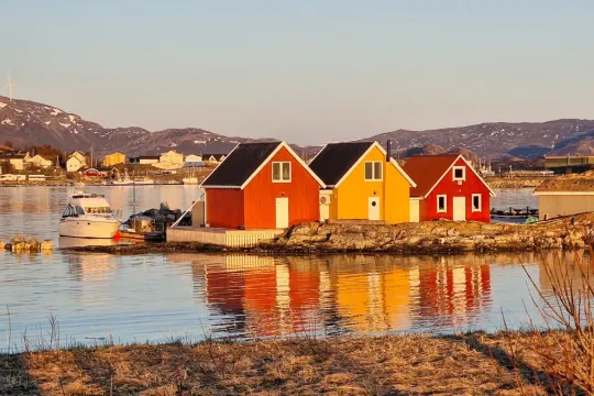 Three houses in sunlight by the shoreline