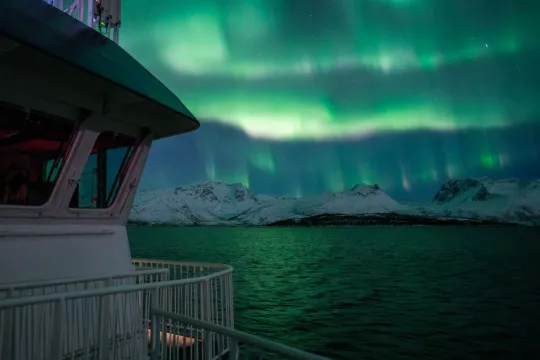 Nordlys over fjorden sett fra dekk på MV Quest under cruiset fra Tromsø.