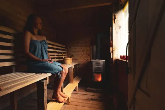 A guest relaxes in the wood-fired sauna during a private stay at OffTrack Experience.