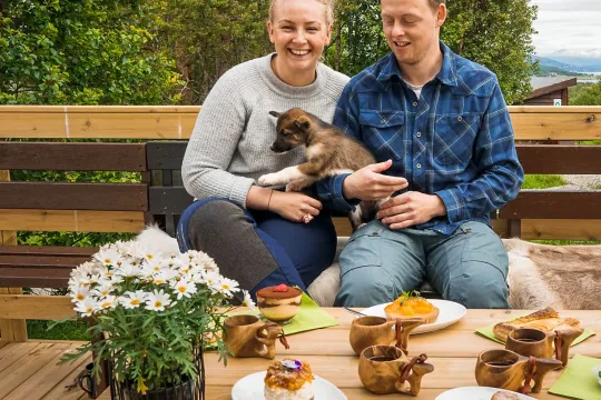 A couple cuddling with a husky puppy