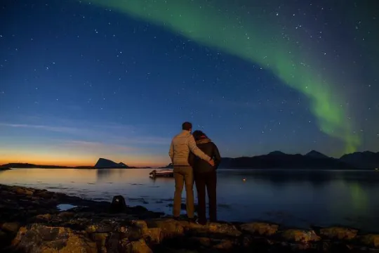 Par ser på nordlyset ved fjorden utenfor Tromsø