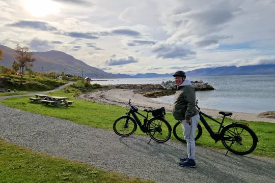 Man by two bikes at the beach