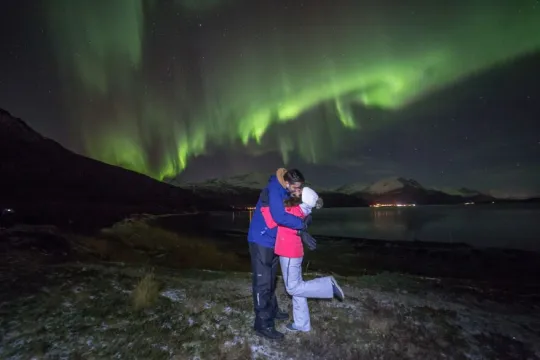 A couple kissing under the northern lights in the Tromso region