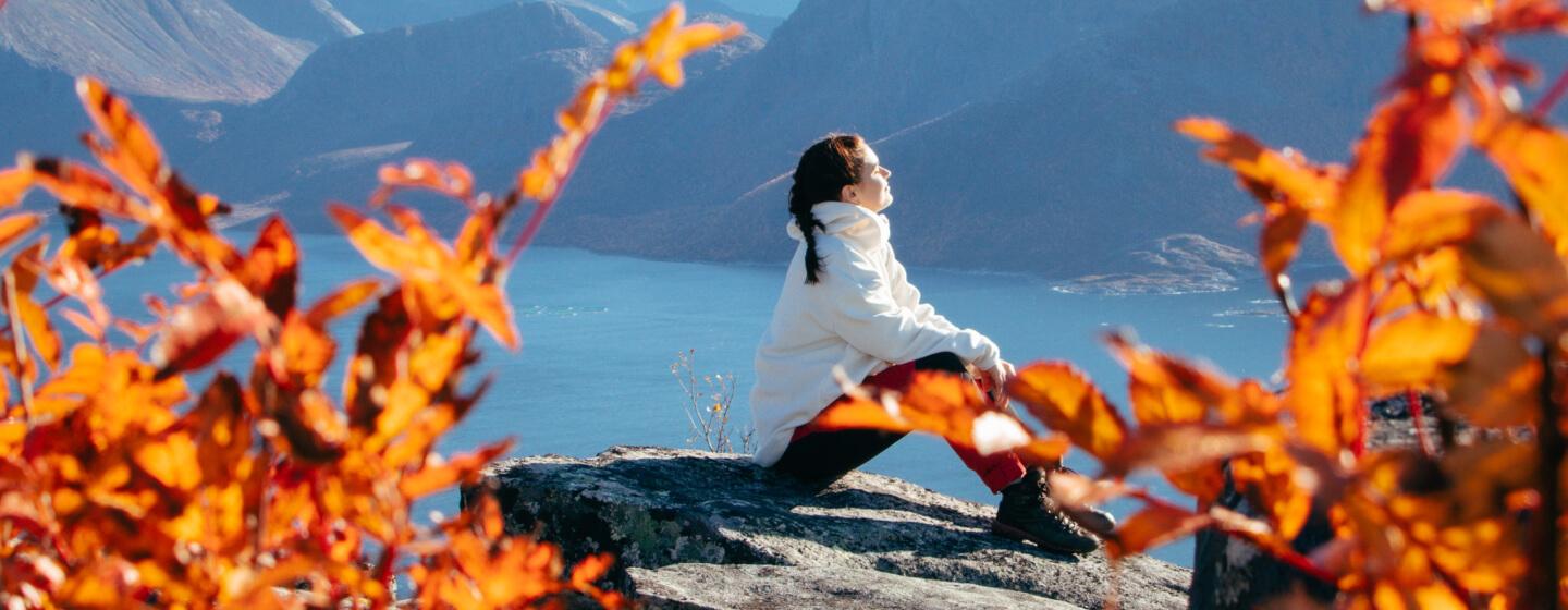 Girl relaxing on the mountain surrounded by autumn colours