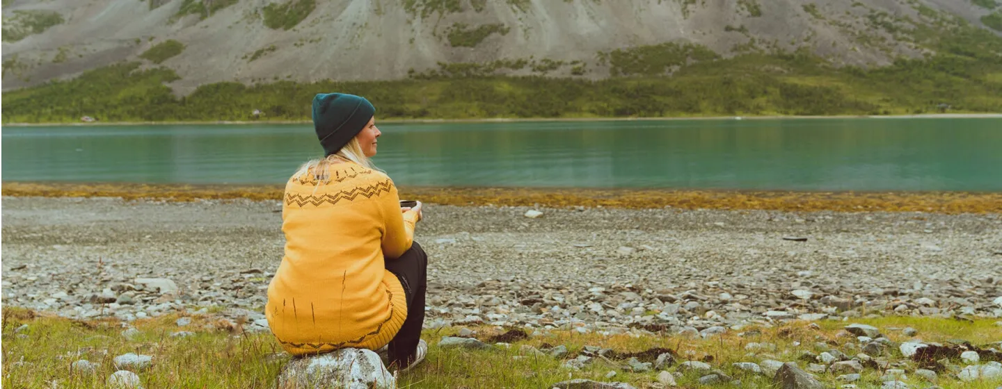 Woman enjoying peace and quiet next to lake in Lyngen 
