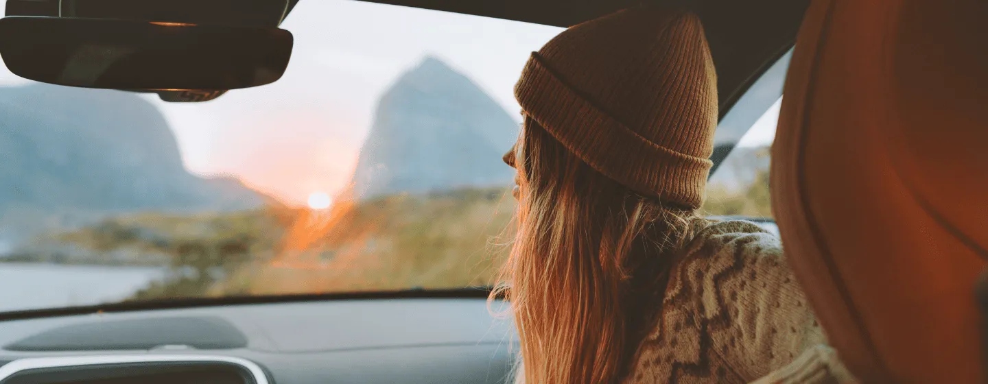 Woman sitting inside a car looking at the view