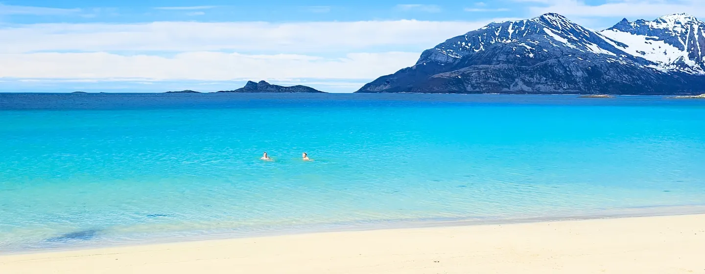 Two persons enjoying a cold swim in the Arctic summer in the Tromso region