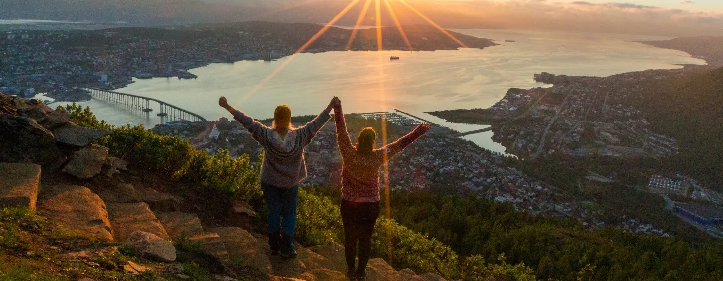 To venninner nyter utsikten og midnattssola fra Sherpatrappa i Tromsø
