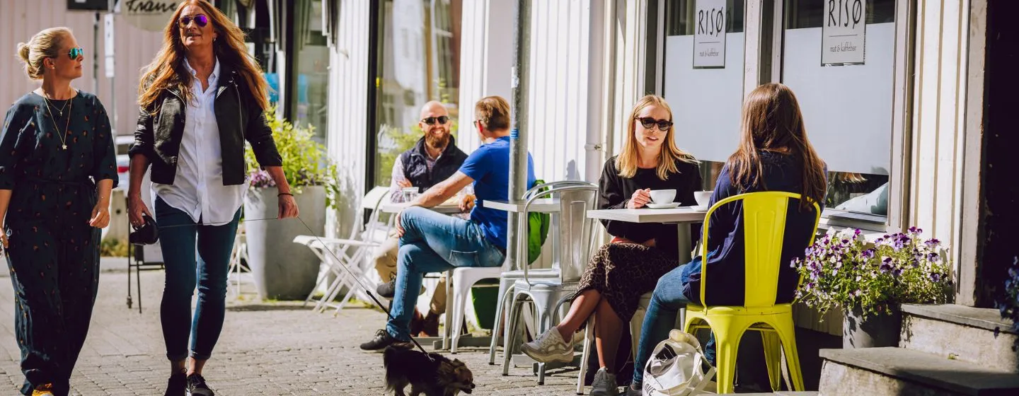 Folk som nyter kaffe på uteservering i Tromsø sentrum