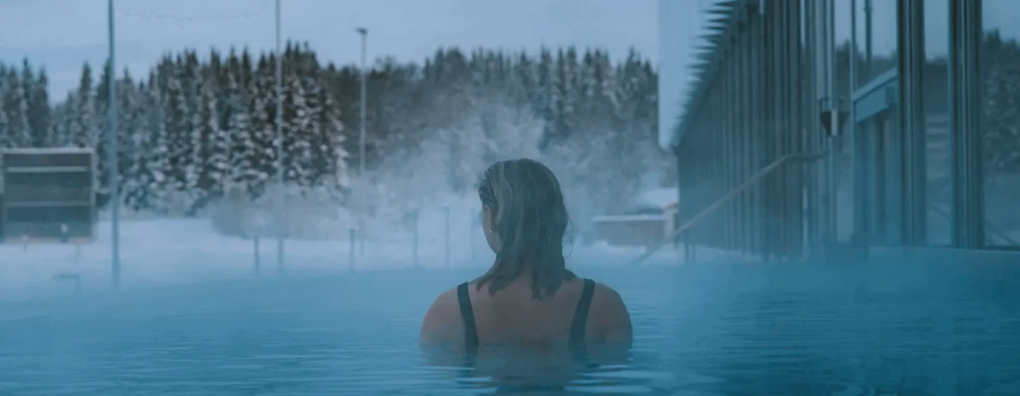 Woman swimming in heated pool in winter