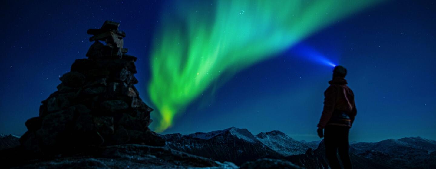 Man in mountains see Northern light