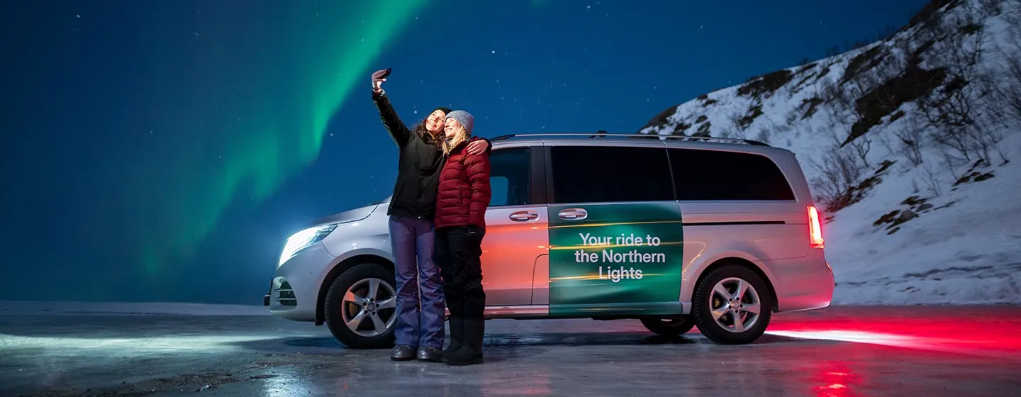 To personer som tar en selfie på nordlystur med Bolt i Tromsøregionen