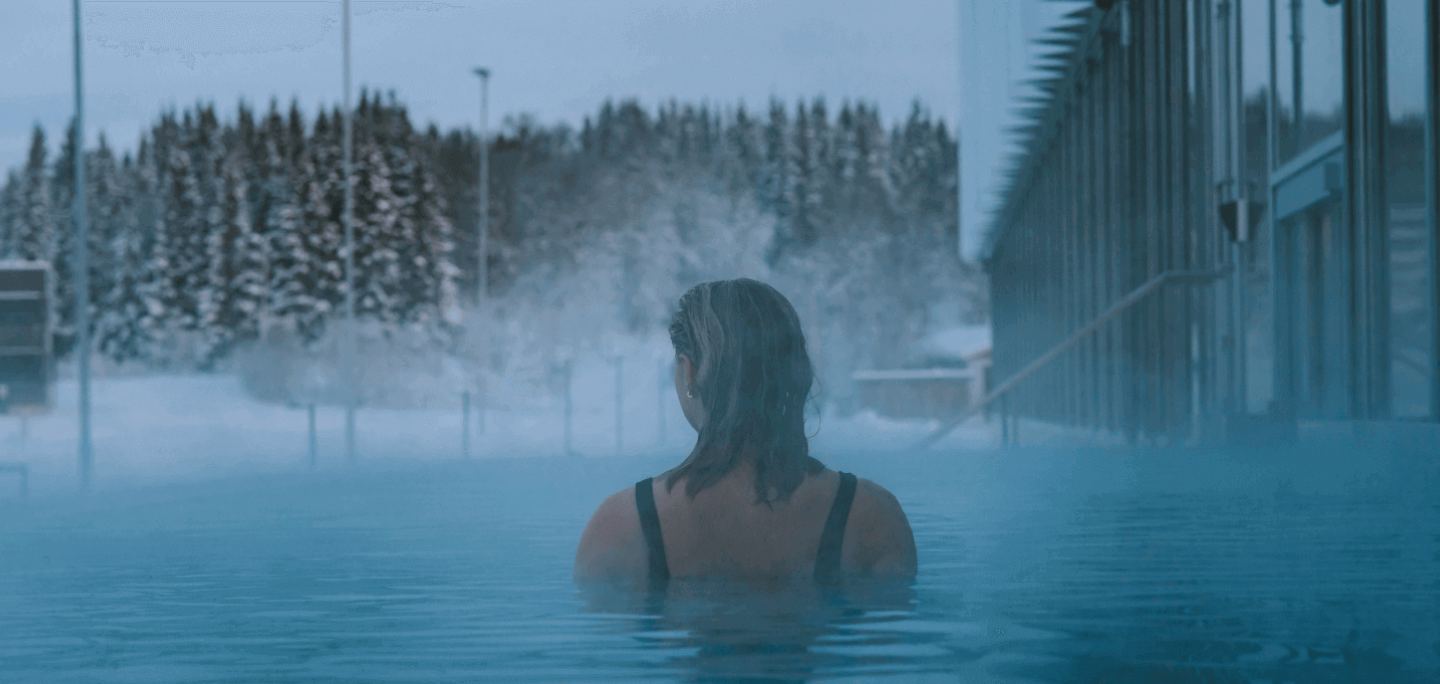 Woman swimming in heated pool in winter