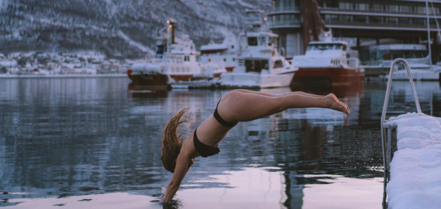 woman refreshing dip in ocean by Pust sauna in Tromsø 