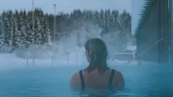 Woman swimming in heated pool in winter